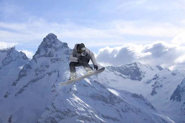 Snowboardista, skákání na horách. Extrémní sport. — Stock fotografie
