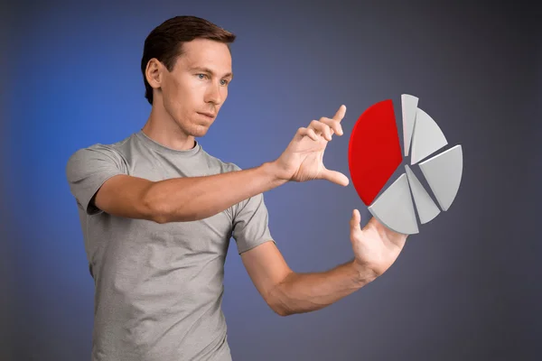 Man in t-shirt werken met cirkeldiagram op blauwe achtergrond. — Stockfoto