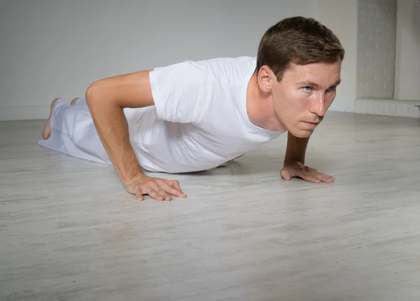 Young man doing pushups on the floor. — Stock Photo, Image