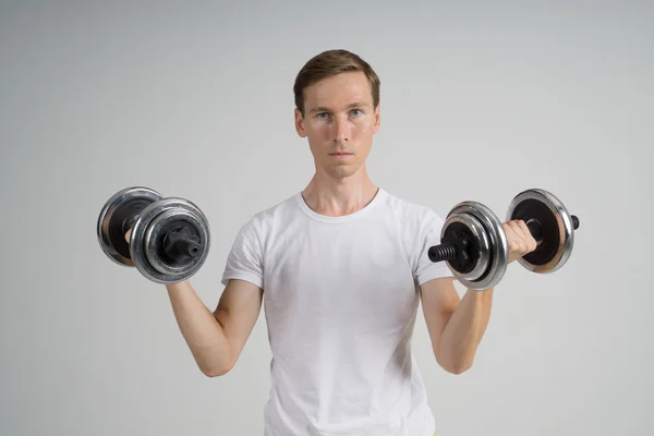 Ung man gör övning med hantlar. — Stockfoto