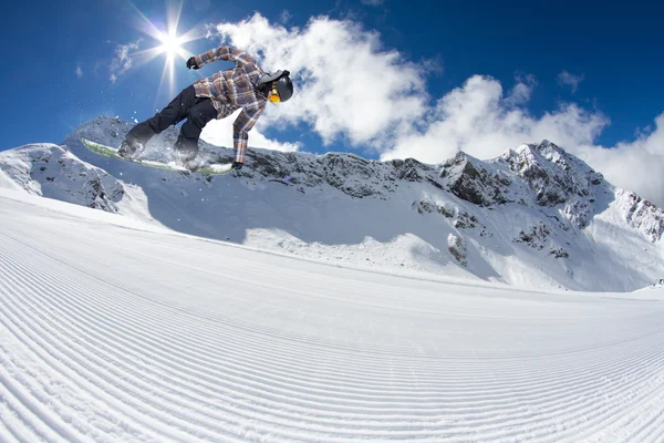 Snowboardåkare hoppa på bergen. Extrem sport. — Stockfoto