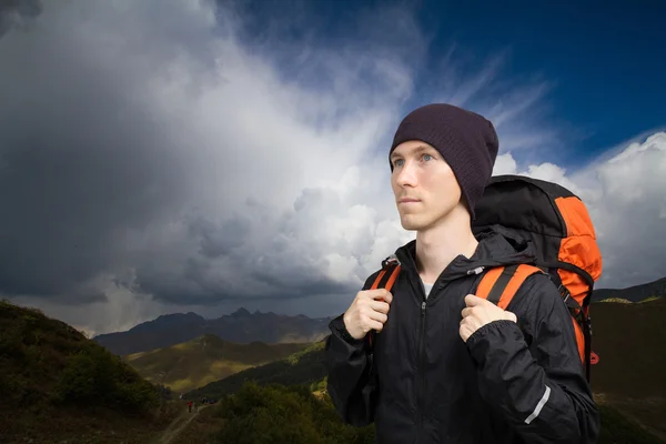 Escursionista uomo sullo sfondo del paesaggio montano con grande nube cumulus . — Foto Stock