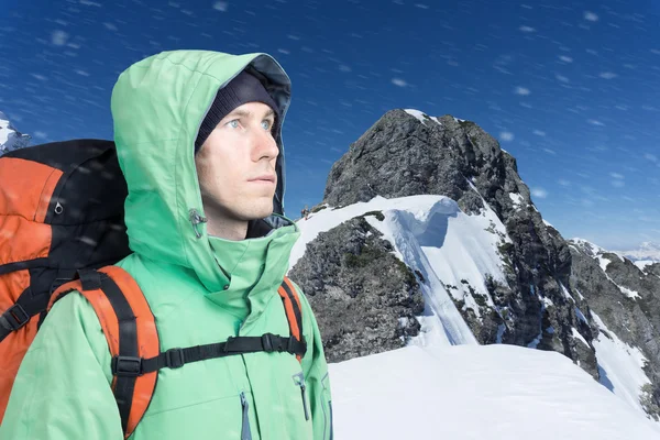 The mountaineer looks at the peak, standing against a winter mountain landscape. — Stock Photo, Image