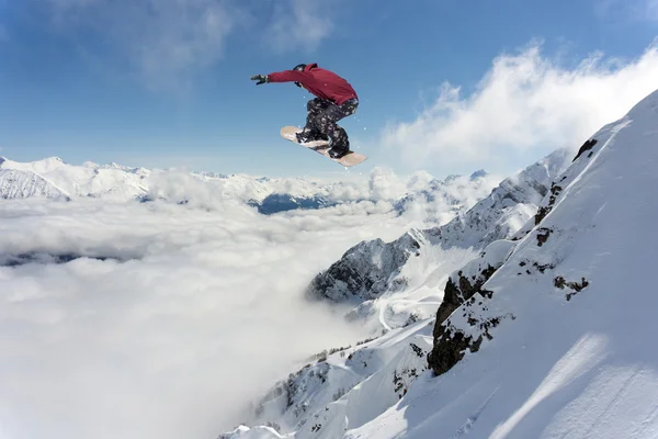 Snowboarder pulando em montanhas nevadas de inverno — Fotografia de Stock