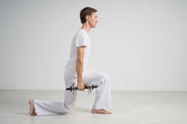 Jovem fazendo exercício com halteres . — Fotografia de Stock