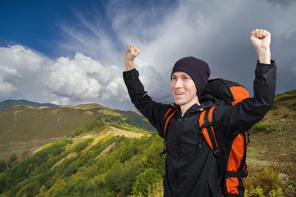 Uomo escursionista con le mani in alto in montagna . — Foto Stock