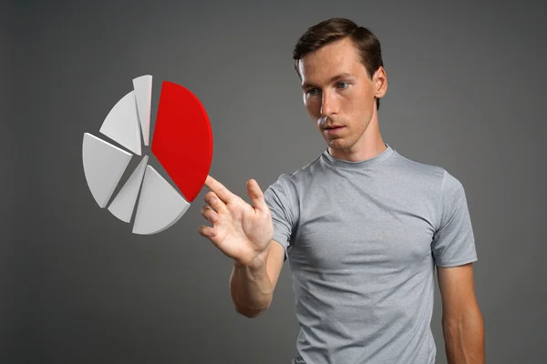 Hombre con camiseta trabajando con gráfico circular sobre fondo gris . —  Fotos de Stock