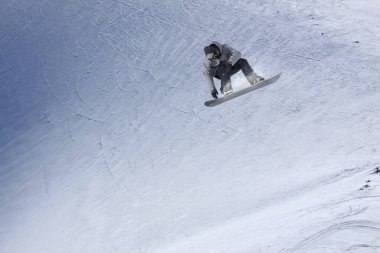 Karlı yamaçta uçan snowboardcu. Kış sporları, snowboard sporları.