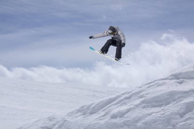 Dağlarda atlayan snowboard binicisi. Ekstrem snowboard serbest spor.