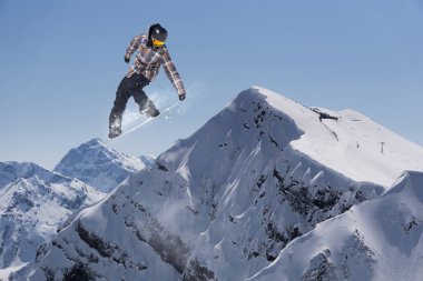 Dağlarda atlayan snowboard binicisi. Ekstrem snowboard serbest spor.