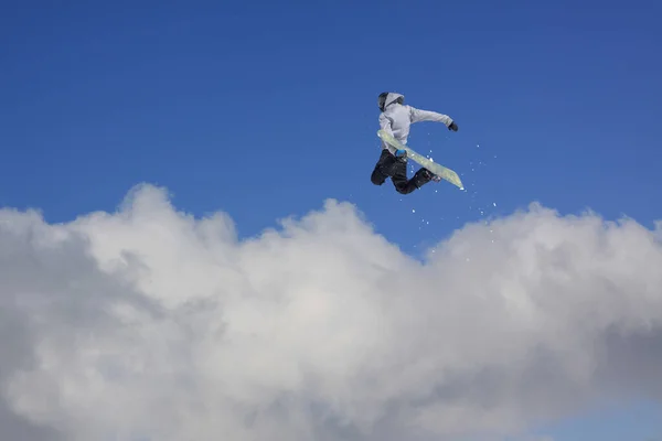 Cavaleiro de snowboard pulando em montanhas. Esporte de freeride de snowboard extremo. — Fotografia de Stock