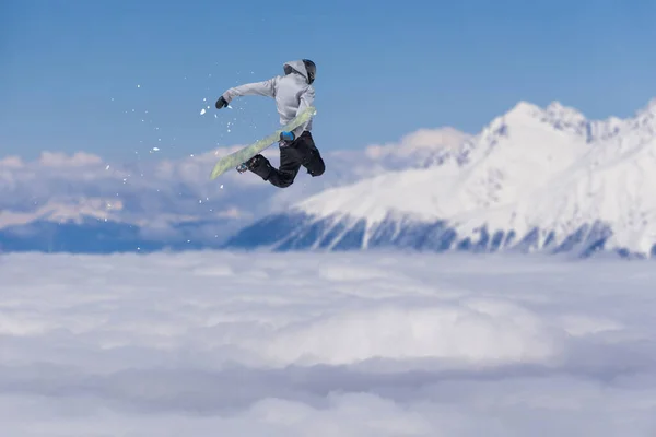 Snowboarder άλμα στα βουνά, ακραία χειμερινά σπορ. — Φωτογραφία Αρχείου