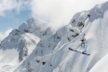 Dağlarda uçan snowboardcu. Ekstrem spor, snowboard sporu.