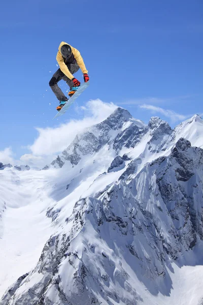 Repülő snowboardos a hegyekben. Extrém sport, snowboard. — Stock Fotó