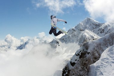 Dağlarda atlayan bir snowboardcu. Snowboard, kış sporu.