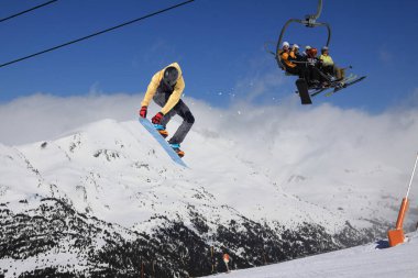 Dağlarda atlayan bir snowboardcu. Snowboard, kış sporu.