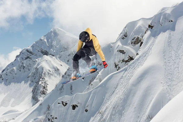 Un snowboardeur qui saute dans les montagnes. Snowboard, sports d'hiver extrêmes. — Photo