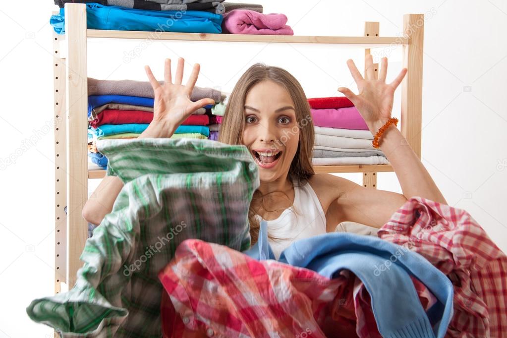 woman throws a pile of clothes, isolated on white