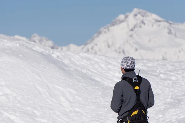 登山者が雪に覆われた山を見てください。 — ストック写真