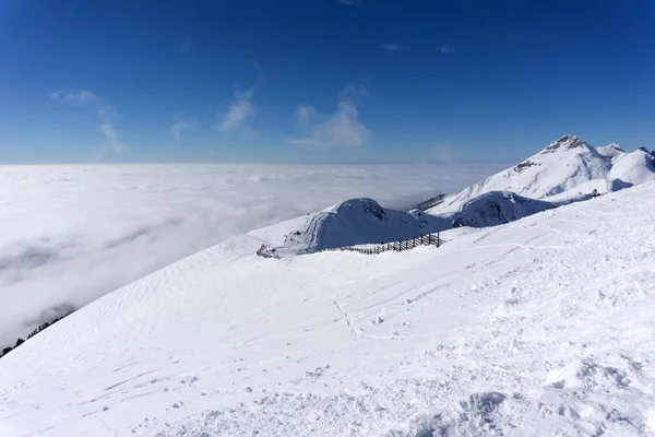 Visa på berg och blå himmel ovanför moln — Stockfoto