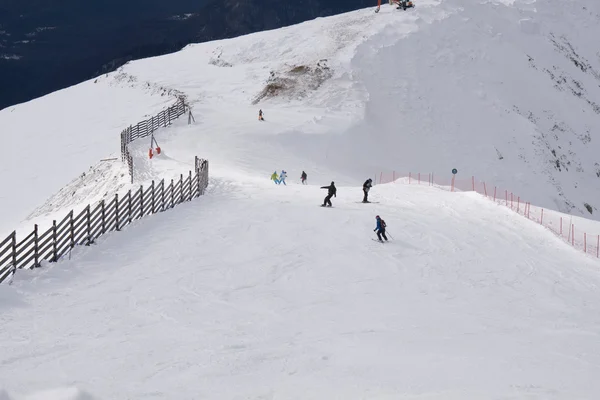 Sciatori e snowboarder che scendono dal pendio . — Foto Stock