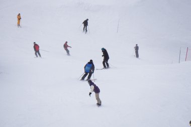 kayakçı ve snowboard düşkünleri yokuş aşağı gidiyor.