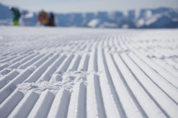 Pistes de dameuse fraîche sur une piste de ski — Photo