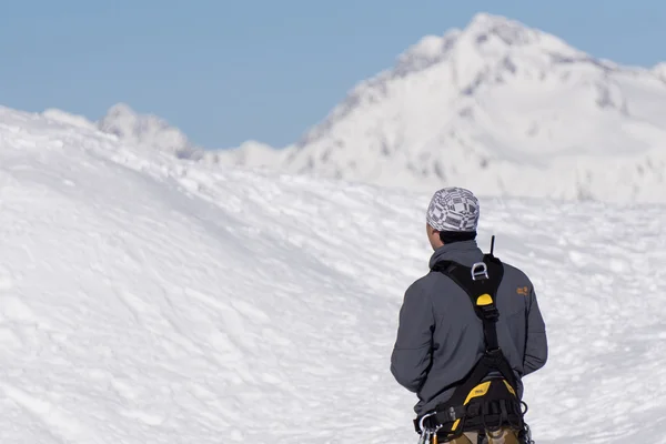 Climber is looking at the snow-covered mountain — Stock Photo, Image