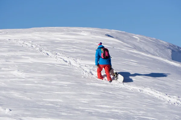Snowboarder αναρρίχηση ένα χιονισμένο βουνό — Φωτογραφία Αρχείου