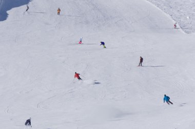 kayakçı ve snowboard düşkünleri yokuş aşağı gidiyor.