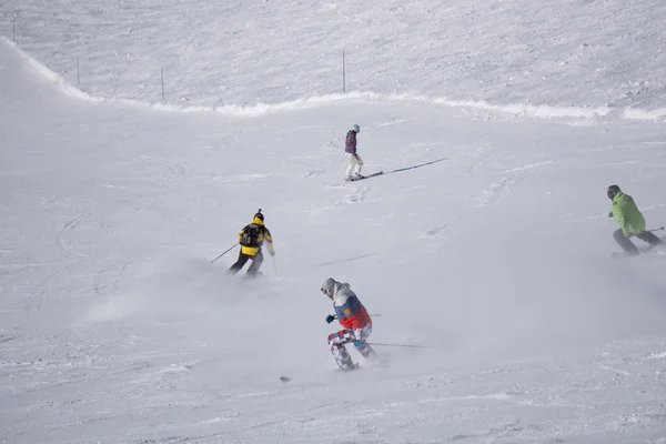 Esquiadores y snowboarders bajando la pendiente . — Foto de Stock