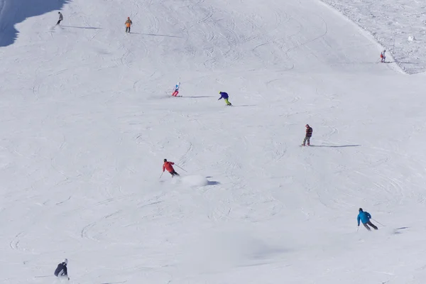 Esquiadores e snowboarders descendo a encosta . — Fotografia de Stock