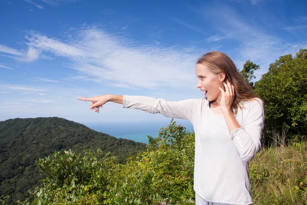 Mädchen steht auf einem Hügel und zeigt in die Ferne — Stockfoto