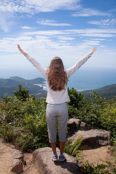 Woman stand seaside rock looking the view with arms open — Stock Photo, Image