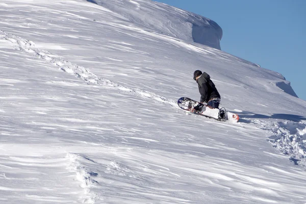 Snowboardåkare klättra en snöig berg — Stockfoto