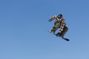 Snowboarder jumps in Snow Park clipart