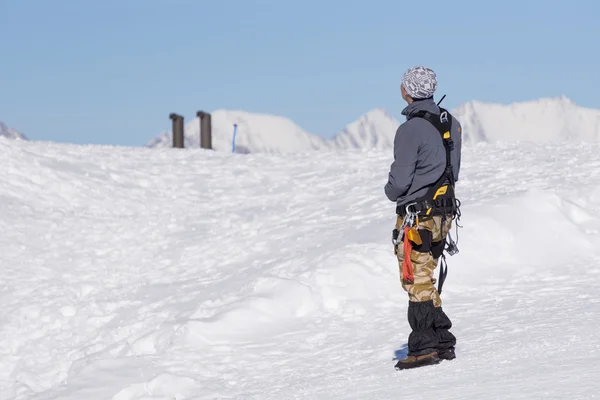Kiipeilijä katselee lumen peittämää vuorta. — kuvapankkivalokuva