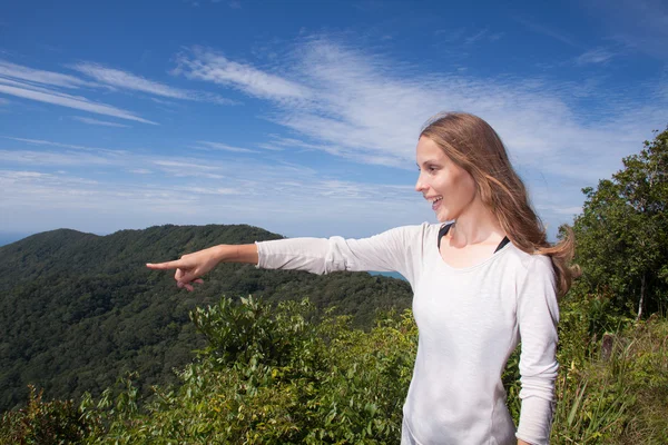 Chica de pie en una colina apunta a la distancia —  Fotos de Stock