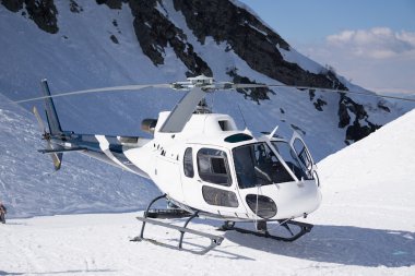 White rescue helicopter parked in the mountains clipart