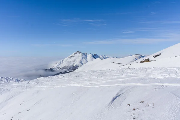 Visa på berg och blå himmel ovanför moln — Stockfoto