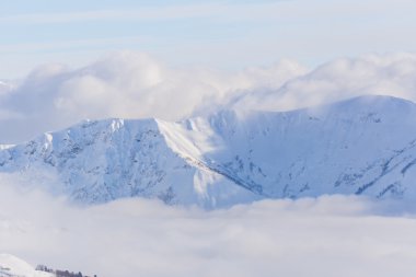 Dağlara ve bulutların üstündeki mavi gökyüzüne bak