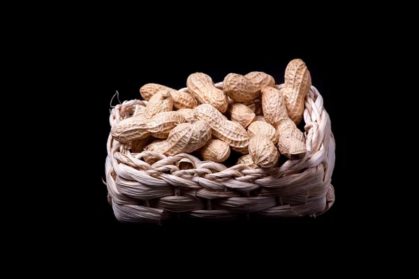 Peanuts isolated in basket on black background — Stock Photo, Image