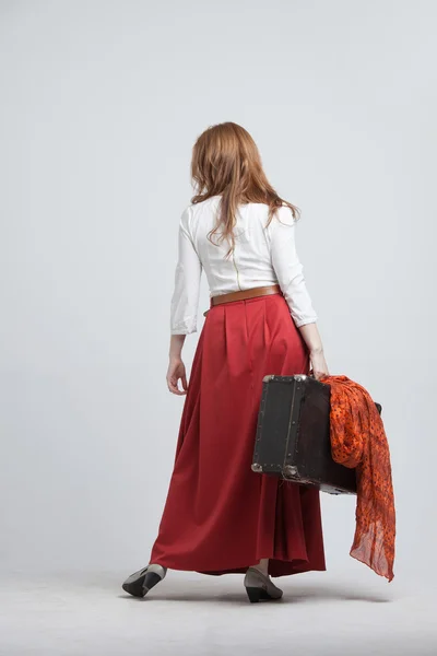 Mulher em saia vermelha vintage com uma mala — Fotografia de Stock