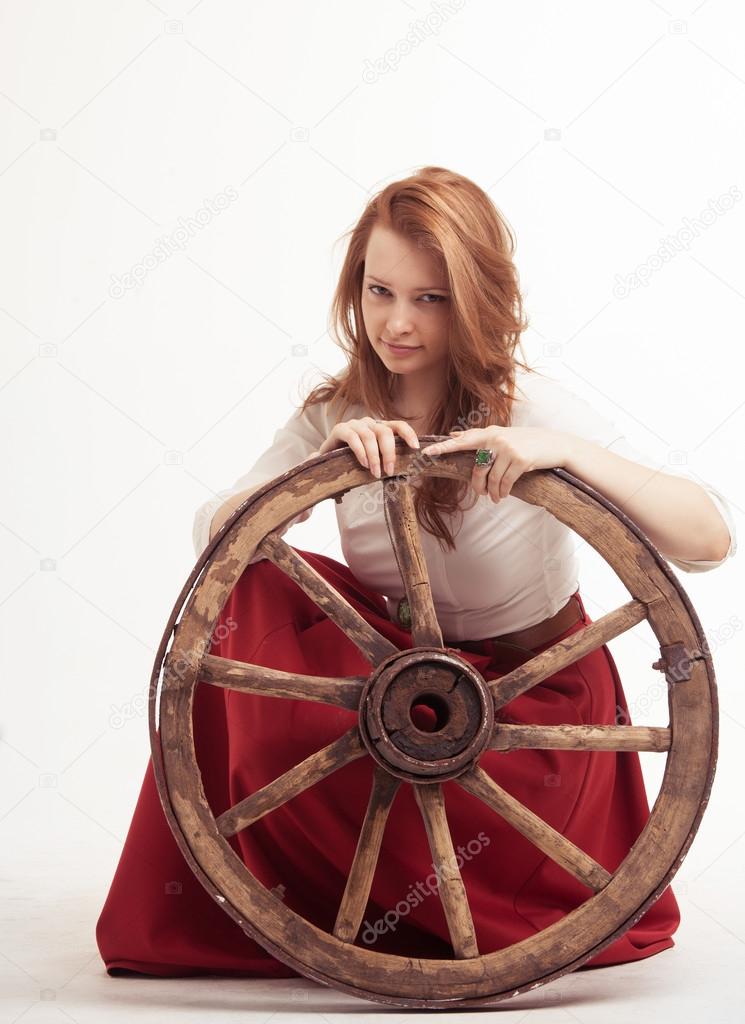 young woman with an old wagon wheel