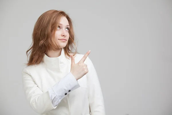 Mulher de casaco branco apontando um dedo — Fotografia de Stock