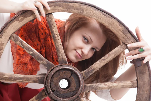 Giovane donna con una vecchia ruota del carro — Foto Stock