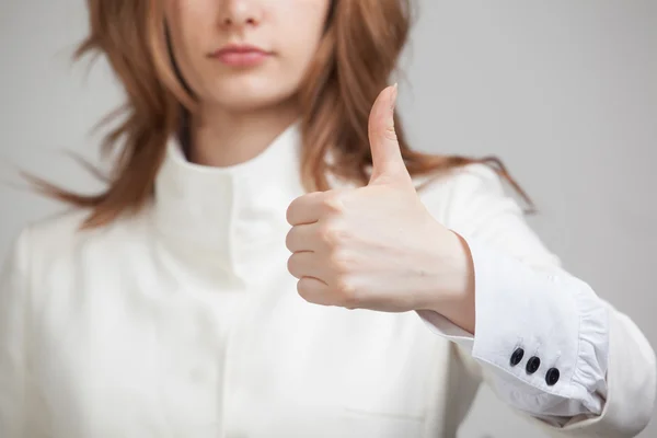 Vrouw in een witte jas verschijnt duim — Stockfoto