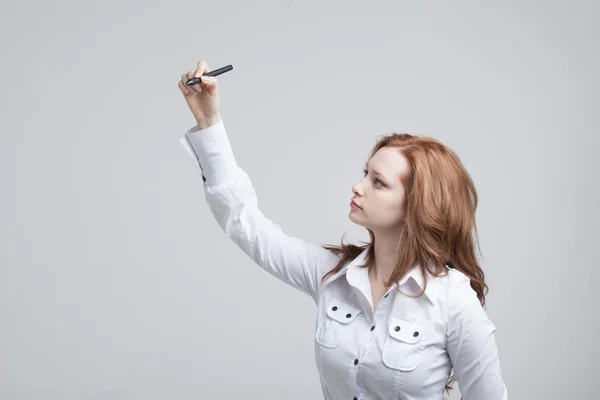 Young woman with pen on grey background — Stock Photo, Image