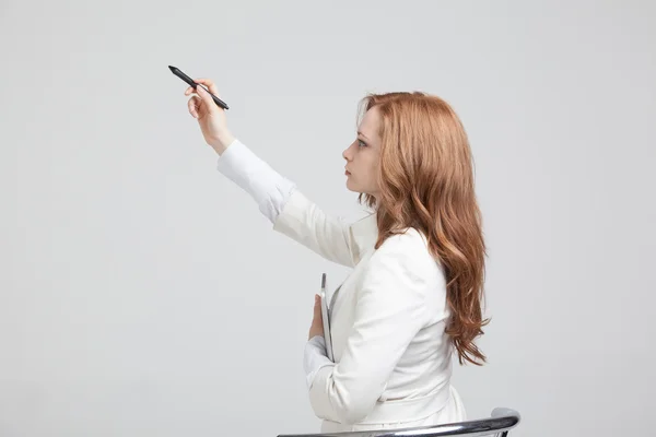 Jeune femme avec stylo sur fond gris — Photo