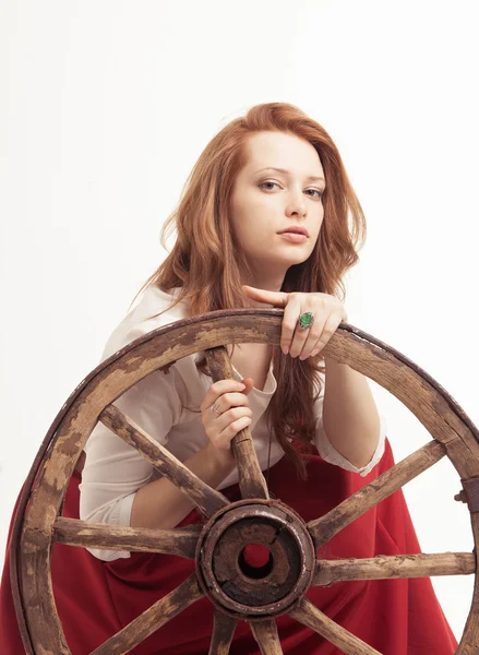 Jeune femme avec une vieille roue de chariot — Photo